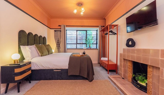 Warm Art-Deco-inspired studio with bath, separate shower, kitchenette and dining area.